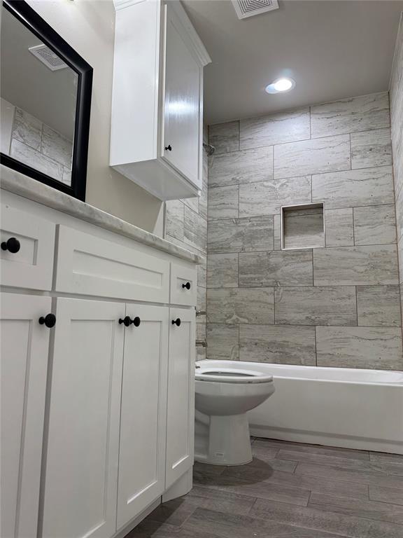 bathroom featuring tiled shower / bath and toilet