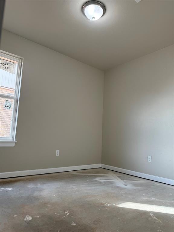 unfurnished room with concrete flooring