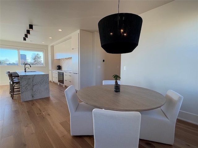 dining space with sink and light hardwood / wood-style flooring