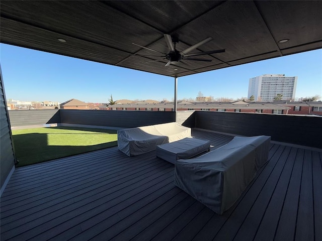 wooden terrace with an outdoor living space, ceiling fan, and a lawn