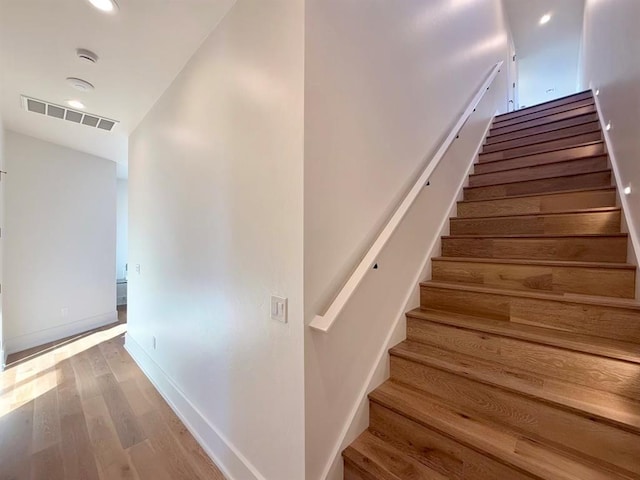 stairs featuring hardwood / wood-style floors