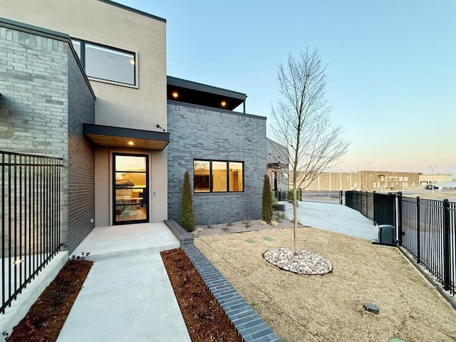 back house at dusk featuring a patio area