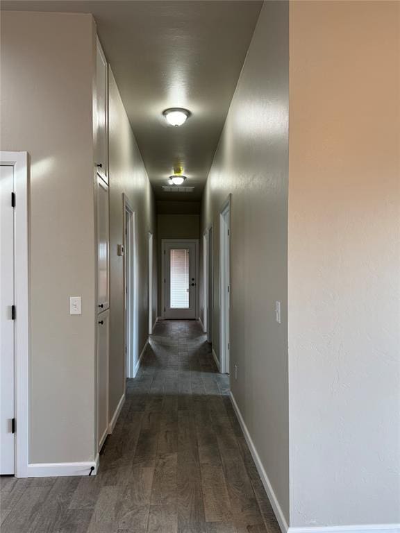 corridor with dark hardwood / wood-style flooring