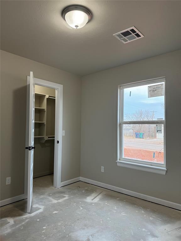 unfurnished bedroom featuring a spacious closet and a closet