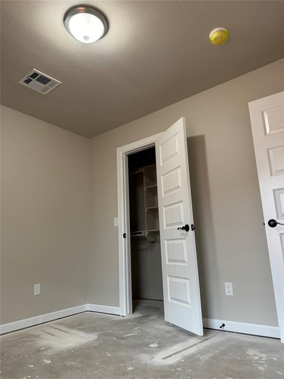 unfurnished bedroom with a spacious closet and a closet