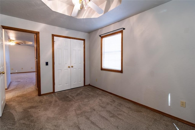 unfurnished bedroom with ceiling fan, carpet flooring, and a closet