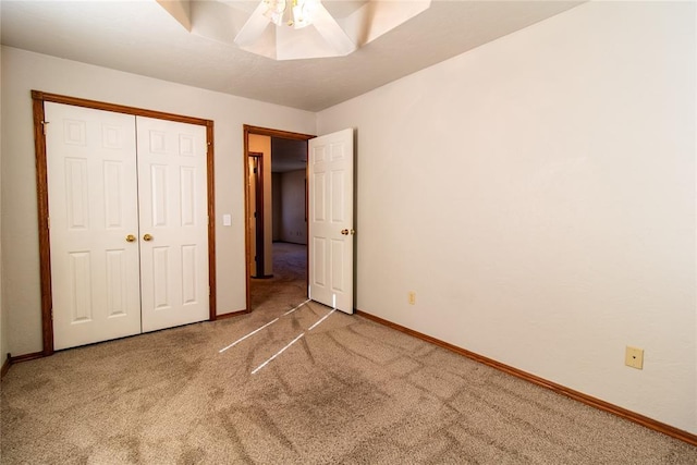 unfurnished bedroom featuring a closet, ceiling fan, and carpet