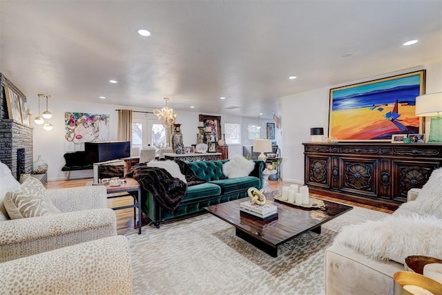 living room featuring a chandelier and light hardwood / wood-style flooring