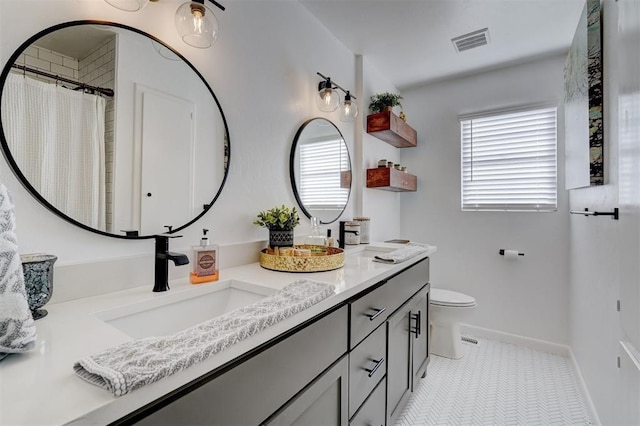 bathroom featuring vanity, tile patterned flooring, and toilet