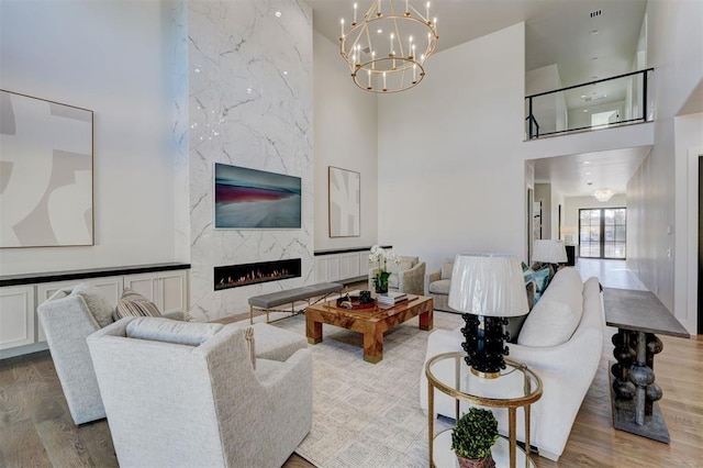 living room featuring hardwood / wood-style flooring, a high end fireplace, and a high ceiling