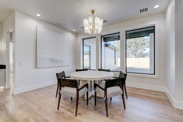 dining area featuring a notable chandelier and light hardwood / wood-style floors