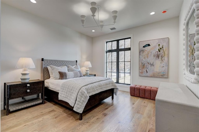 bedroom with light hardwood / wood-style flooring and a chandelier