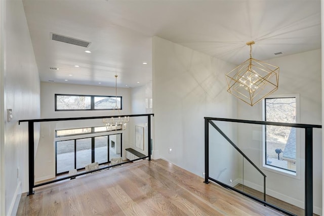 spare room with hardwood / wood-style flooring and a notable chandelier