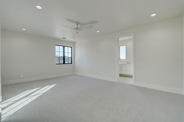 carpeted spare room featuring ceiling fan