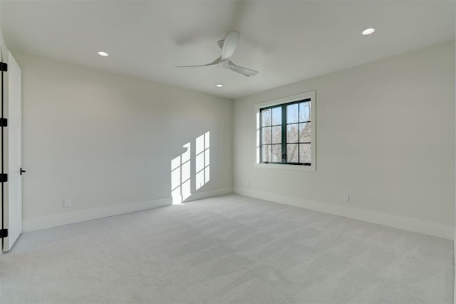 spare room with light colored carpet and ceiling fan