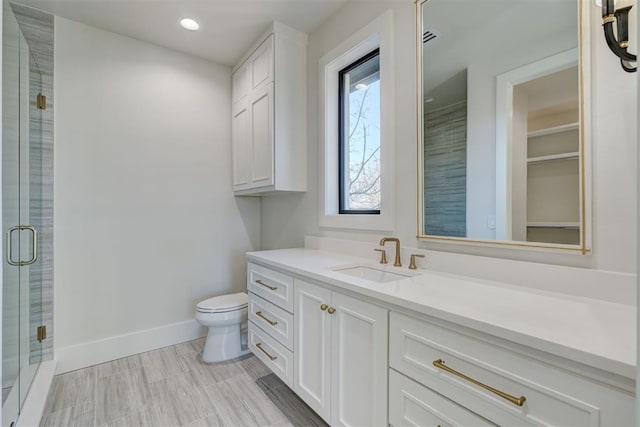 bathroom with vanity, an enclosed shower, and toilet