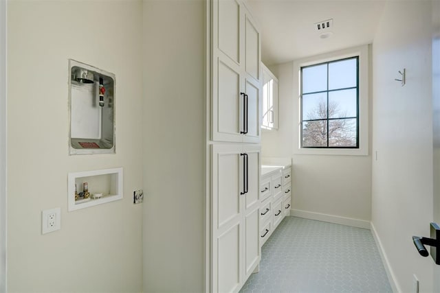 laundry room with cabinets, hookup for a washing machine, and light tile patterned floors