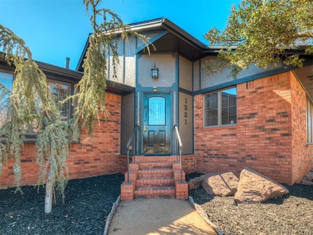 property entrance featuring brick siding and stucco siding