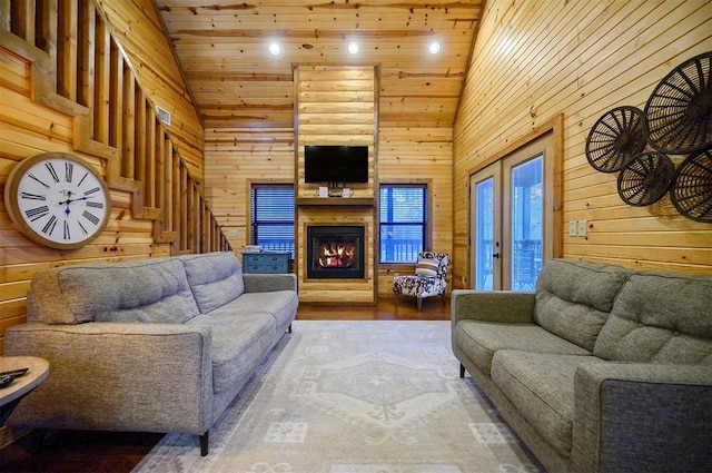 living room featuring high vaulted ceiling, wood ceiling, and wood walls