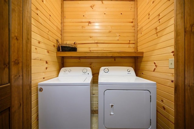 washroom with wooden walls and independent washer and dryer