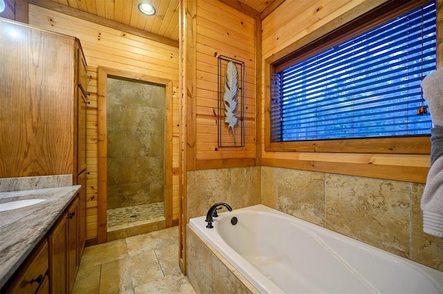 bathroom featuring vanity, wooden walls, and independent shower and bath