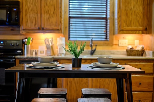 kitchen featuring butcher block countertops, black appliances, and sink