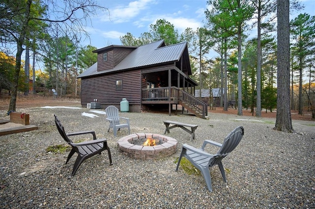 back of property featuring a wooden deck and an outdoor fire pit