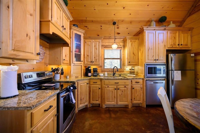 kitchen with vaulted ceiling, appliances with stainless steel finishes, sink, hanging light fixtures, and light stone countertops