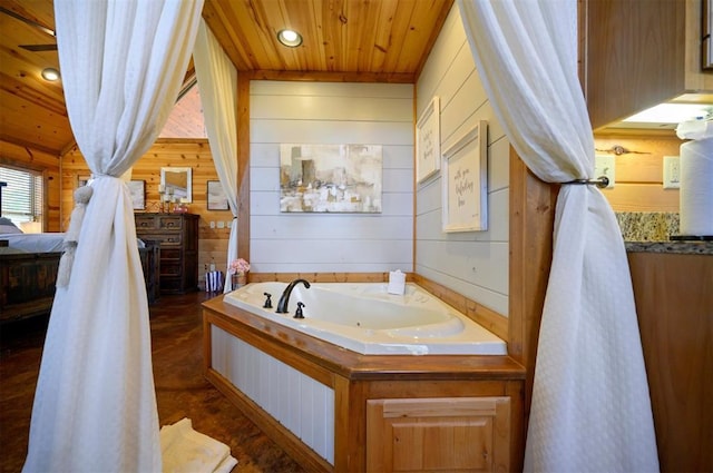 bathroom featuring wooden ceiling, a bath, and wood walls