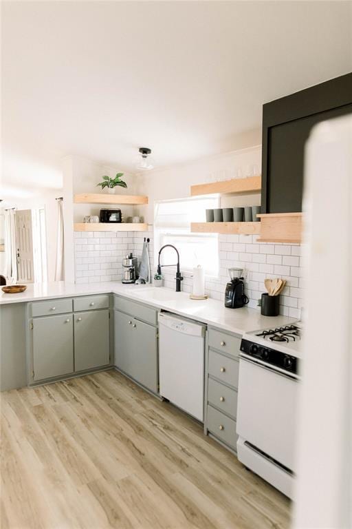 kitchen with white appliances, sink, light hardwood / wood-style flooring, and backsplash