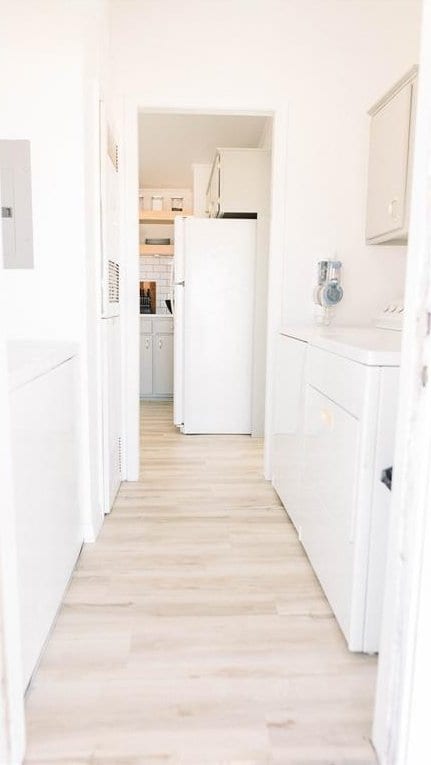 hall featuring electric panel and light hardwood / wood-style floors