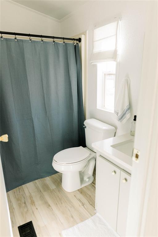 bathroom with vanity, hardwood / wood-style floors, crown molding, and toilet