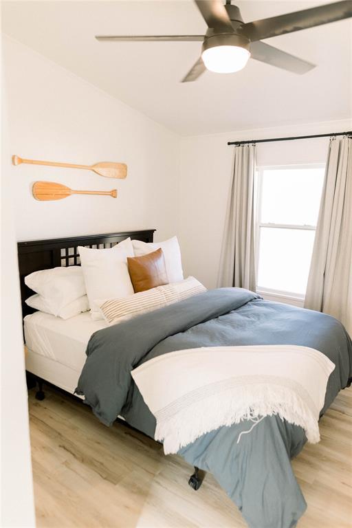 bedroom featuring ceiling fan, lofted ceiling, and light hardwood / wood-style floors