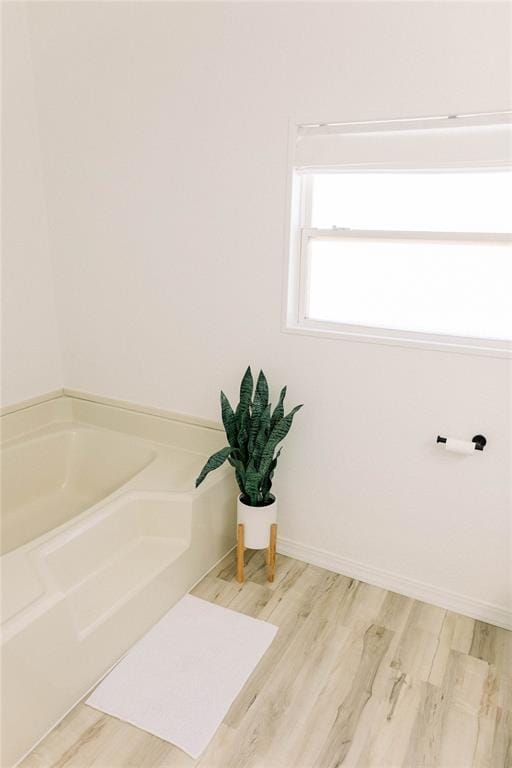 bathroom with a bath and wood-type flooring