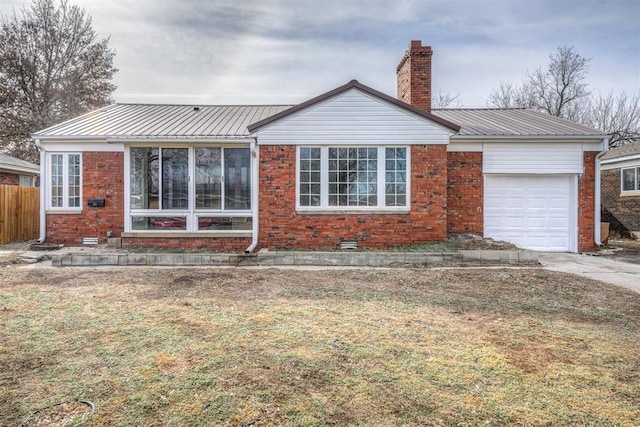 back of house featuring a garage and a lawn