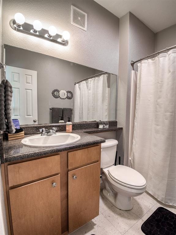 bathroom with vanity, toilet, and tile patterned flooring