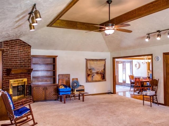 living area featuring lofted ceiling, a brick fireplace, light colored carpet, and ceiling fan