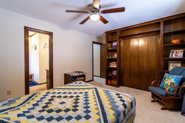 bedroom featuring connected bathroom, light colored carpet, a closet, and ceiling fan