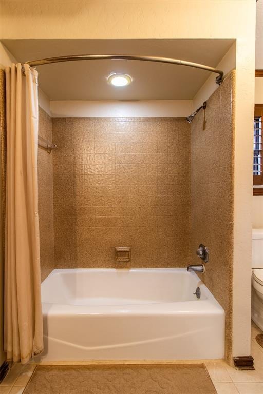 bathroom featuring shower / tub combo with curtain, toilet, and tile patterned flooring