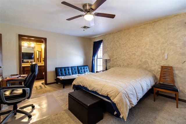 bedroom featuring visible vents, baseboards, carpet, ensuite bath, and a ceiling fan