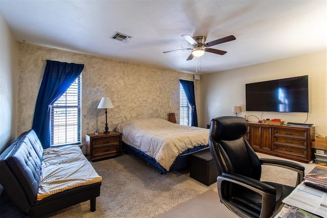 bedroom featuring visible vents, multiple windows, a ceiling fan, and carpet floors