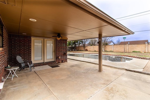 view of patio with ceiling fan, a fenced backyard, and a fenced in pool