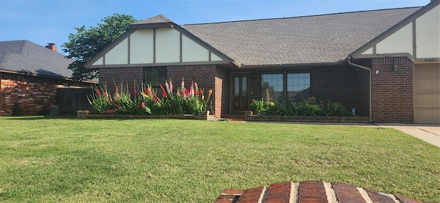 tudor-style house with brick siding, stucco siding, a shingled roof, and a front lawn