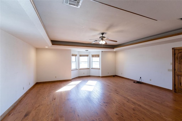 spare room with ceiling fan, a raised ceiling, and hardwood / wood-style floors