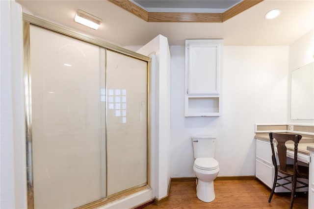 bathroom with wood-type flooring, toilet, vanity, and walk in shower