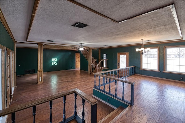 interior space with hardwood / wood-style flooring, a textured ceiling, and a notable chandelier