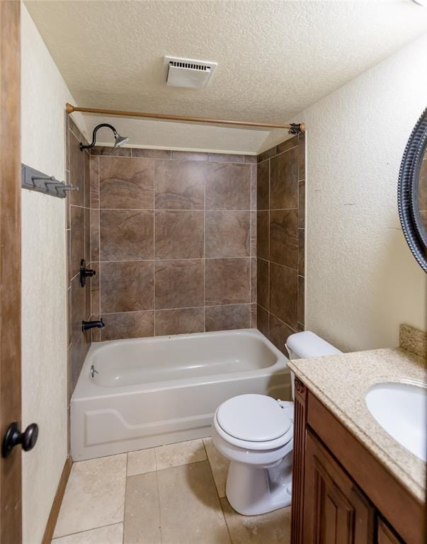 full bathroom featuring vanity, tiled shower / bath combo, toilet, and a textured ceiling