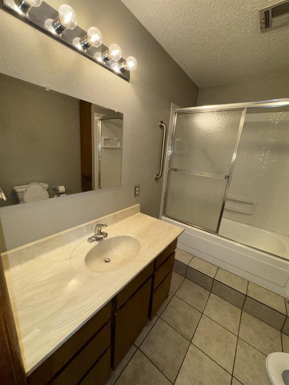 full bathroom with toilet, shower / bath combination with glass door, a textured ceiling, vanity, and tile patterned flooring