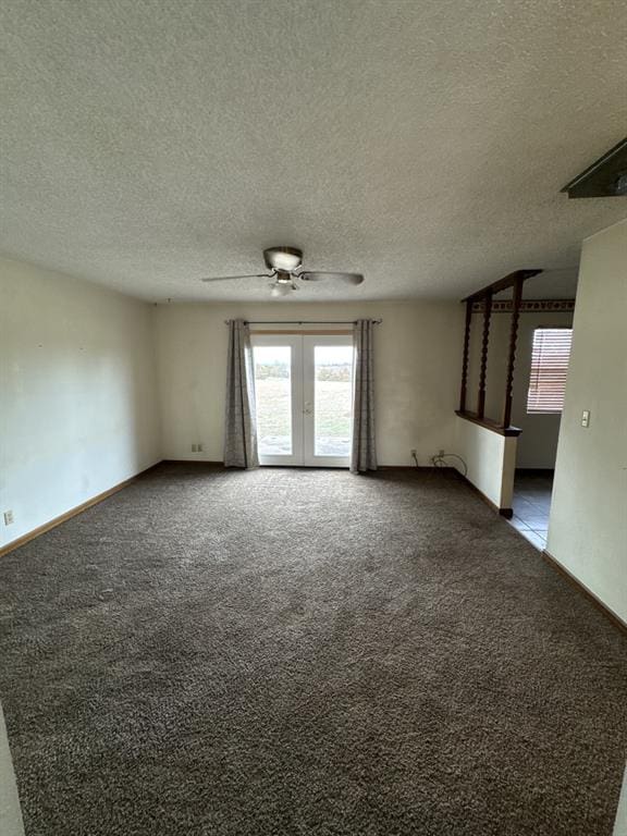 unfurnished room featuring ceiling fan, dark carpet, french doors, and a textured ceiling