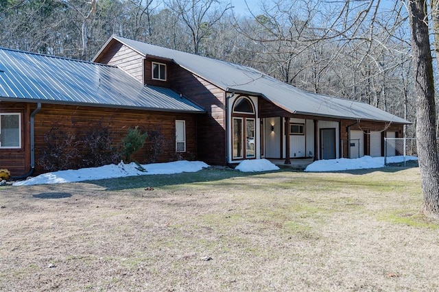 view of front facade with metal roof and a front lawn